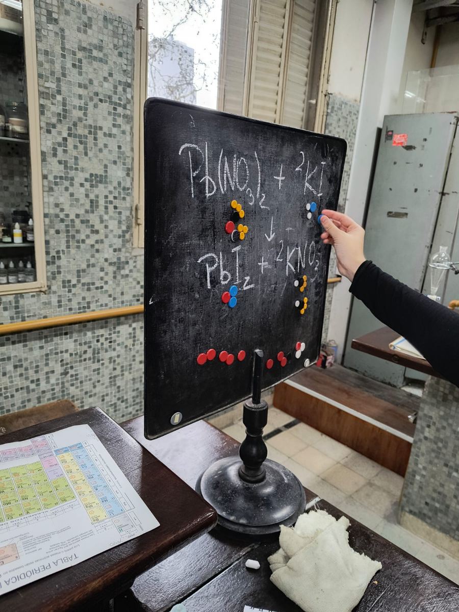 Representación de una reacción química con fichas sobre el pizarrón.