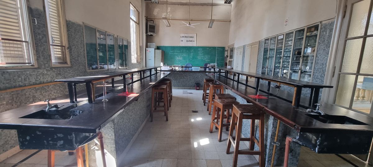 Laboratorio de química con mesadas y banquetas.